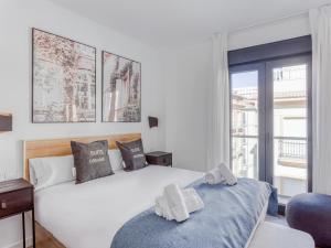 马拉加limehome Málaga Calle Ancha del Carmen - Digital Access的卧室配有白色的床和窗户。