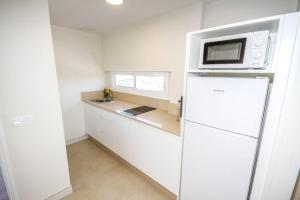 圣阿古斯丁New Miami Playa Apartamentos的带冰箱的白色厨房,配有微波炉
