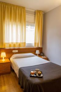 卡斯特尔德费尔斯139酒店的一间卧室配有一张床,上面放着一个食物托盘
