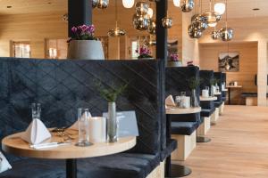 巴尔德赫旺Torghele's Wald & Fluh的餐厅的一排桌子和黑椅子