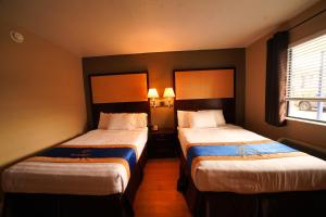代托纳海滩Sandals Inn的酒店客房设有两张床和窗户。