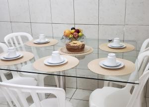 纳塔尔Confortável apartamento próximo à Ponta Negra的一张带帽子的玻璃桌和蛋糕
