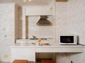 拉科鲁尼亚Apartamentos Portazgo的白色的厨房配有微波炉和水槽