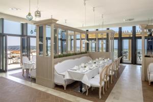 普拉亚德尔瑞伊Royal Obidos Spa & Golf Resort的一间带桌椅和窗户的用餐室