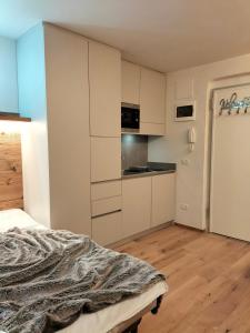 摩德纳迪-坎皮格里奥Appartamento Campiglio 2的卧室配有白色橱柜和一张床