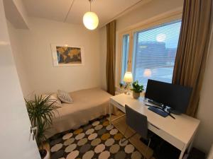 万塔Modern two bedroom apartment near Helsinki Airport的客房设有一张书桌、一台电脑和一张床