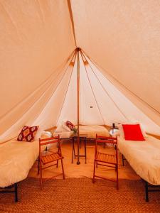 CoramWander Camp Glacier的帐篷内的房间,配有两张床和两把椅子
