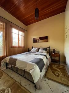 普拉曼塔4 Seasons Tzoumerka Senses的一间卧室设有一张带木制天花板的大床