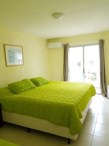 埃斯特角城Hotel La Vista 32的一间卧室设有一张绿色的床和一个窗户。