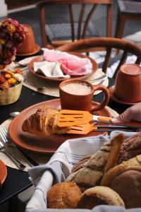 瓦哈卡市Casa Naila Hotel Boutique的餐桌,盘子上放着面包和咖啡