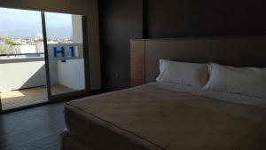 卡塔马卡H1 Apartments Hotel的一间卧室设有一张大床和一个大窗户