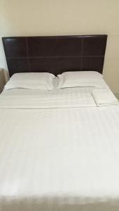 拿笃海洋酒店的一张带白色床单和黑色床头板的床