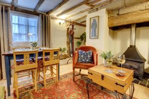 沃里克Tudor Cottage by Spa Town Property - Historic Charm in Warwick Town Centre的客厅配有桌子和壁炉