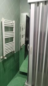 那不勒斯那不勒斯住宿加早餐旅馆的浴室设有镜子和绿色瓷砖墙