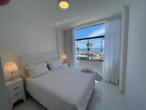 萨尔瓦多SALVADOR Ondina 3 quartos frente praia的白色的卧室设有床和大窗户
