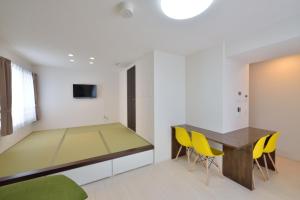 端岛Guest House Gifuhashima COCONE / Vacation STAY 33938的一间带桌子和黄色椅子的用餐室