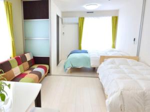 端岛Guest House Gifuhashima COCONE / Vacation STAY 30285的一间卧室配有一张床、一张沙发和一面镜子