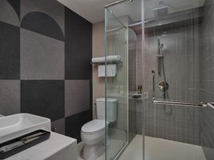 曼谷UHG 安努季节酒店的一间带卫生间和玻璃淋浴间的浴室
