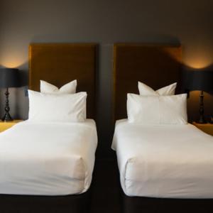 基督城Hotel Montreal的配有2张床铺的酒店客房,提供白色床单和枕头