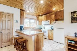 格兰德莱克Bald Mountain Views的厨房配有木制橱柜和白色冰箱。