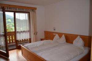 崔聂斯Falkenau的一间卧室配有一张带白色床单的床和一扇窗户。