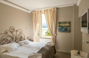 勒威诺Relais Villa Porta的一间卧室设有一张大床和一个窗户。
