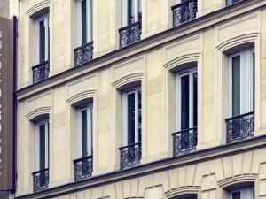 巴黎巴黎皮加勒圣心大教堂美居酒店的建筑的外墙,设有窗户和阳台