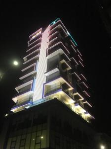 马德望V V Hotel Battambang的一座高大的建筑,上面有灯,晚上