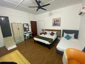 乔治市BoraBora Beach Guesthouse Penang的一间卧室配有两张床和吊扇