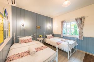 浦阿Baan Kang Hun Pua Cottage的蓝色墙壁客房的两张床