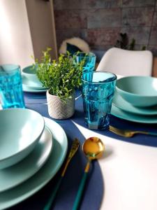 格拉斯哥Stylish 2 bedroom Apartment / FREE Gated Parking的蓝色桌子,上面有盘子和碗,还有勺子