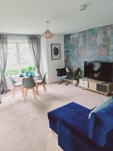 格拉斯哥Stylish 2 bedroom Apartment / FREE Gated Parking的客厅配有蓝色的沙发和电视