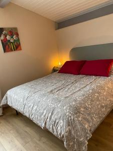 蒙卡雷Le Jasmin的一间卧室配有一张带红色枕头的大床