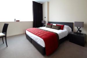 伦敦世外桃源酒店的一间卧室配有一张带红色毯子的大床