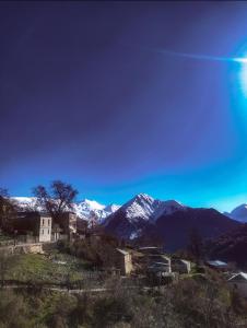 卡拉利特斯Αρχοντικό Βογιάρου的一座山丘上的建筑,有积雪覆盖的山脉