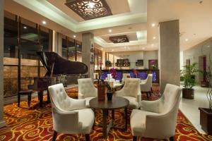 茂物帕加加兰套房度假及会议酒店的一间设有钢琴和桌椅的餐厅