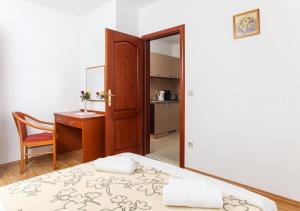 洛帕德Apartments Ana的一间卧室配有一张床、一张书桌和一面镜子