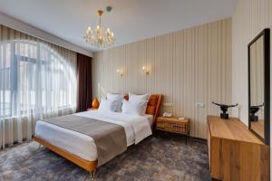 第比利斯Mukhrantubani Boutique Hotel的酒店客房设有一张大床和吊灯。