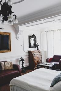 姆拉哥沃太阳能宫SPA&康体酒店的一间卧室配有一张床、一张沙发和一台电视。