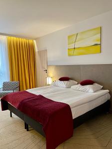 华沙Arche Hotel Krakowska的一间卧室配有一张带红色毯子的大床