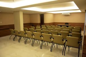 萨尔瓦多Pituba Praiamar Hotel的会议室,里面摆放着椅子和讲台