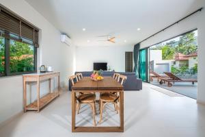 通奈潘海滩T villas的客厅配有桌子和沙发