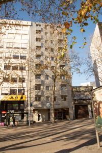 波尔图Hotel Porto Interface Trindade By Kavia的前面有一棵树的高楼