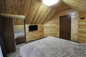 布克维Melody Hotel的一间卧室设有一张床,木制天花板上配有电视。
