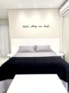 贝卢港Apto Loft Novo - Porto Belo - 5 min a pé da praia的一间卧室,卧室里配有一张床,上面写着字条,