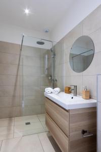 卡尔热斯Casa Marina Cargèse的浴室配有盥洗盆和带镜子的淋浴