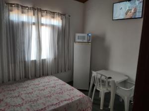 博拉塞亚Pousada Familiar Morada do Rapha的一间卧室配有一张床、一张桌子和一台电视。