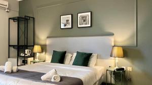 斯利马斯丽马滨海酒店的一间卧室设有两张带绿色墙壁的床和两盏灯。