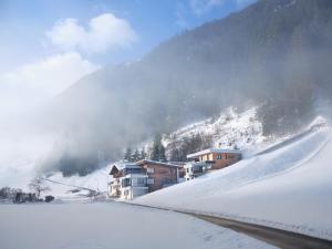 伊施格尔Sun Lodge的一座雪覆盖的山中,有房子和滑雪场