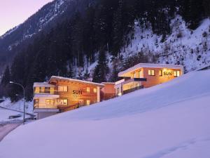 伊施格尔Sun Lodge的雪覆盖的山前的一组建筑